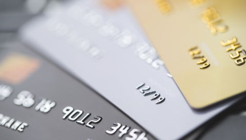 Soft focus close up of different coloured credit cards arranged in fan formation(black silver and gold)