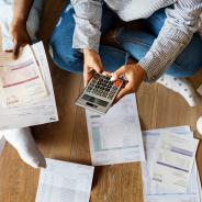 Two people sitting sitting in a pile of bills  