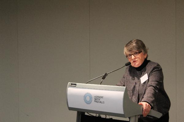 Picture of Justice Bell speaking at a lectern