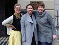 Three woman with their arms around each other standing outside Redfern Legal Centre