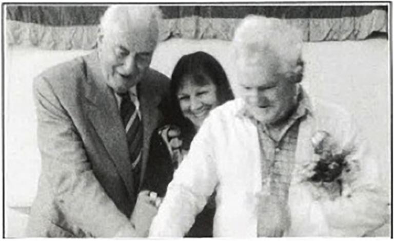 Three figures cutting a cake