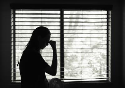 Black and while photo of a female silhouette against window