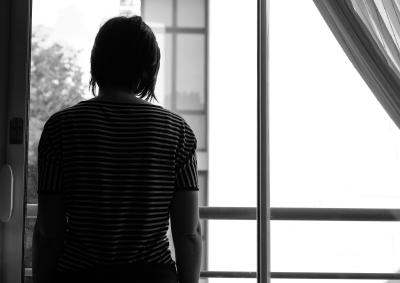 a woman silhouetted at a window in a home