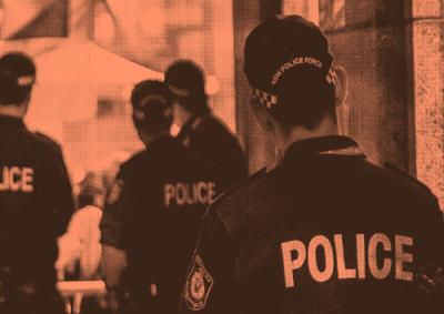 Group of police stand backs away from camera image tinted orange