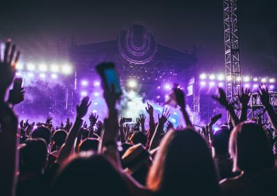 Crowd at a festival with hands in the air holding mobile phones