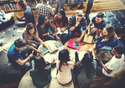 Overhead view of a large group of students studying at desk.