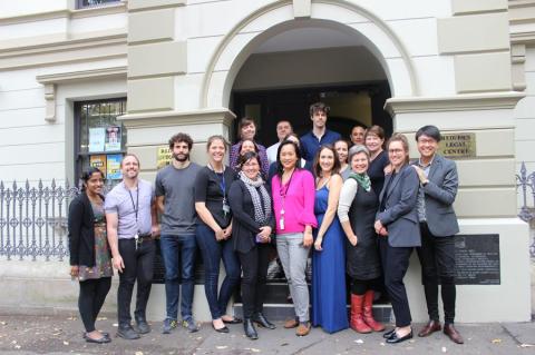 Large group of people standing and smiling outside Redfern Legal Centre's front steps