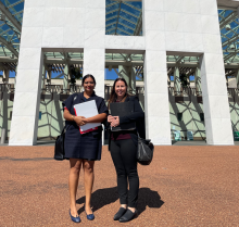 Two women stand outside Parliament House