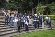 Group of international students standing outside on a set of stairs in an ampitheatre