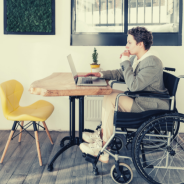 Employment and workplace discrimination thumbnail - profile of a woman working on a laptop. She's seated in a wheelchair.