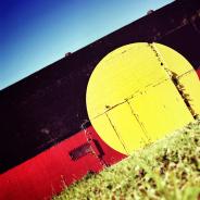 First Nations Justice - Aboriginal Flag Painted on Wall