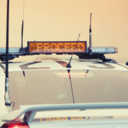 Policy Accountability Thumbnail - Police Car zoomed in on roof mounted sign saying proceed