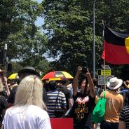 Protesters on a main road holding Aboriginal flags