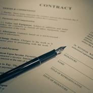 Typed contract with a pen lying over it