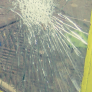 Closeup of a smashed window on a yellow door