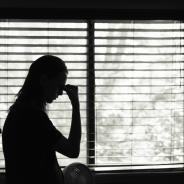Black and while photo of a female silhouette against window