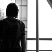 a woman silhouetted at a window in a home