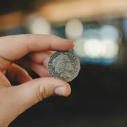 Fingers holding up an Australian fifty cent coin